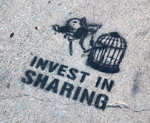 "Invest in sharing!" A street art stencil featuring the "get out of jail free" card image from Monopoly board-game. Found painted on the sidewalk in New York City in 2007.